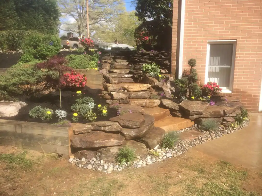 Photo of landscaping services and stone steps with flowers.