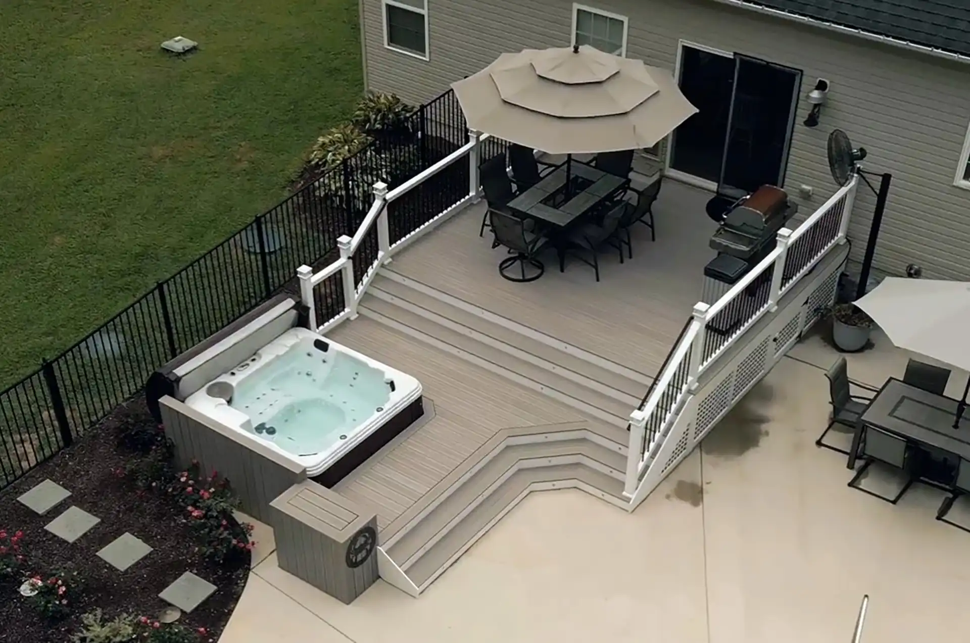 Aerial view of multi-level deck with an outdoor dining area and hot tub