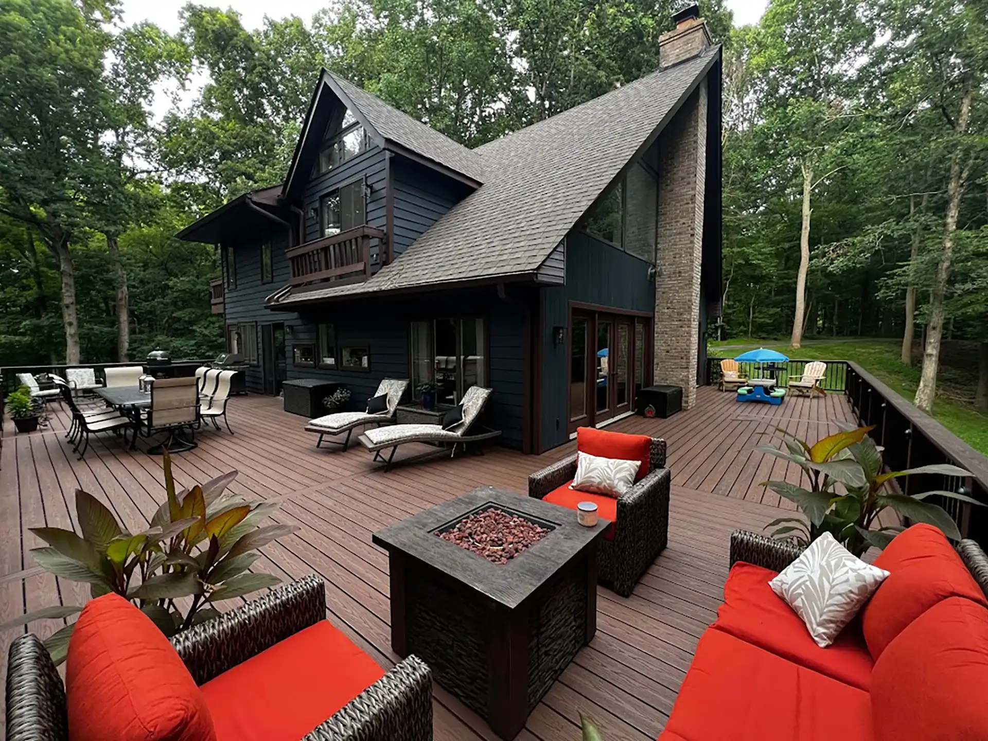 Photo of an expansive custom deck with outdoor fire features and furniture