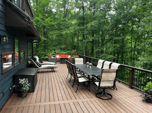 Composite deck ideas - elevated deck with outdoor furniture in a wooded setting